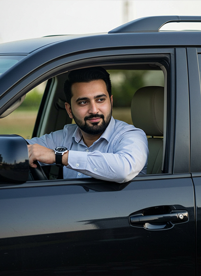 A professional driver in a black Toyota Prado, available for rent with a driver from Micro Car Rental in Islamabad.