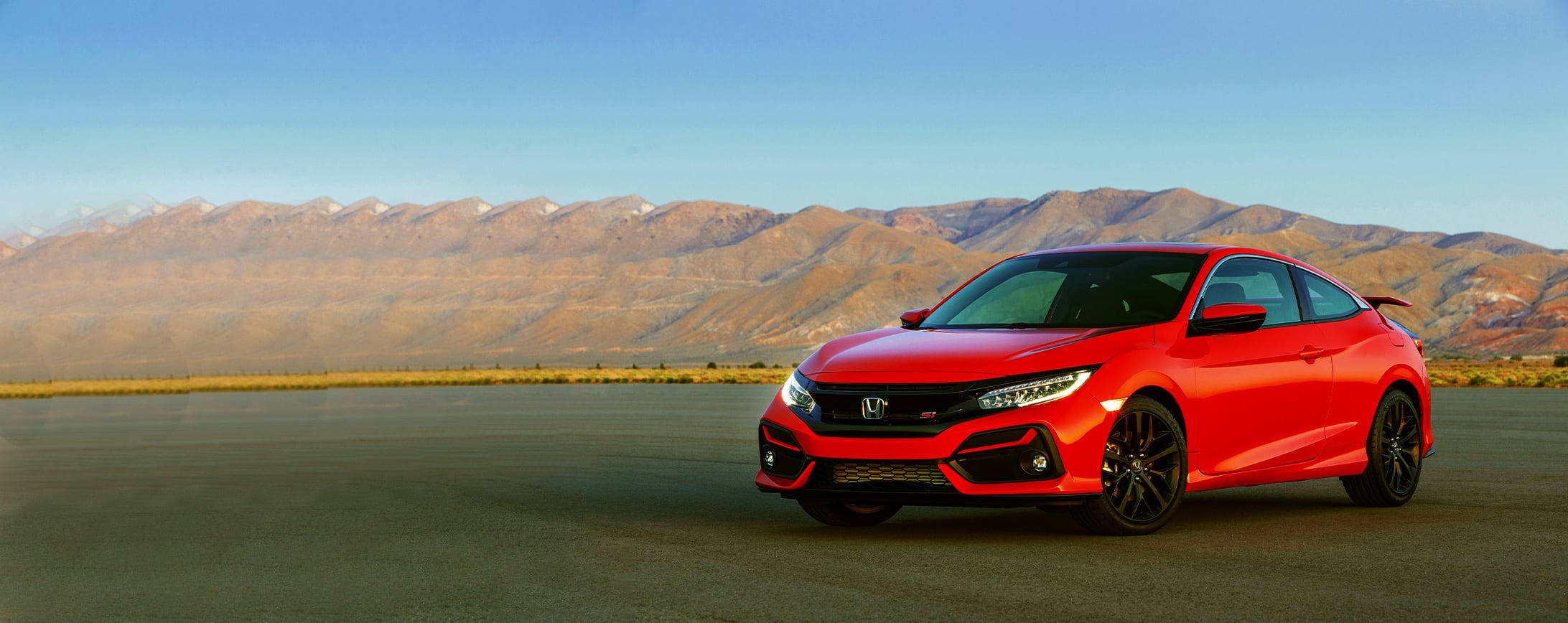 Image of a clean red Honda Civic for rent on a scenic drive from Micro Car Rental in Islamabad.
