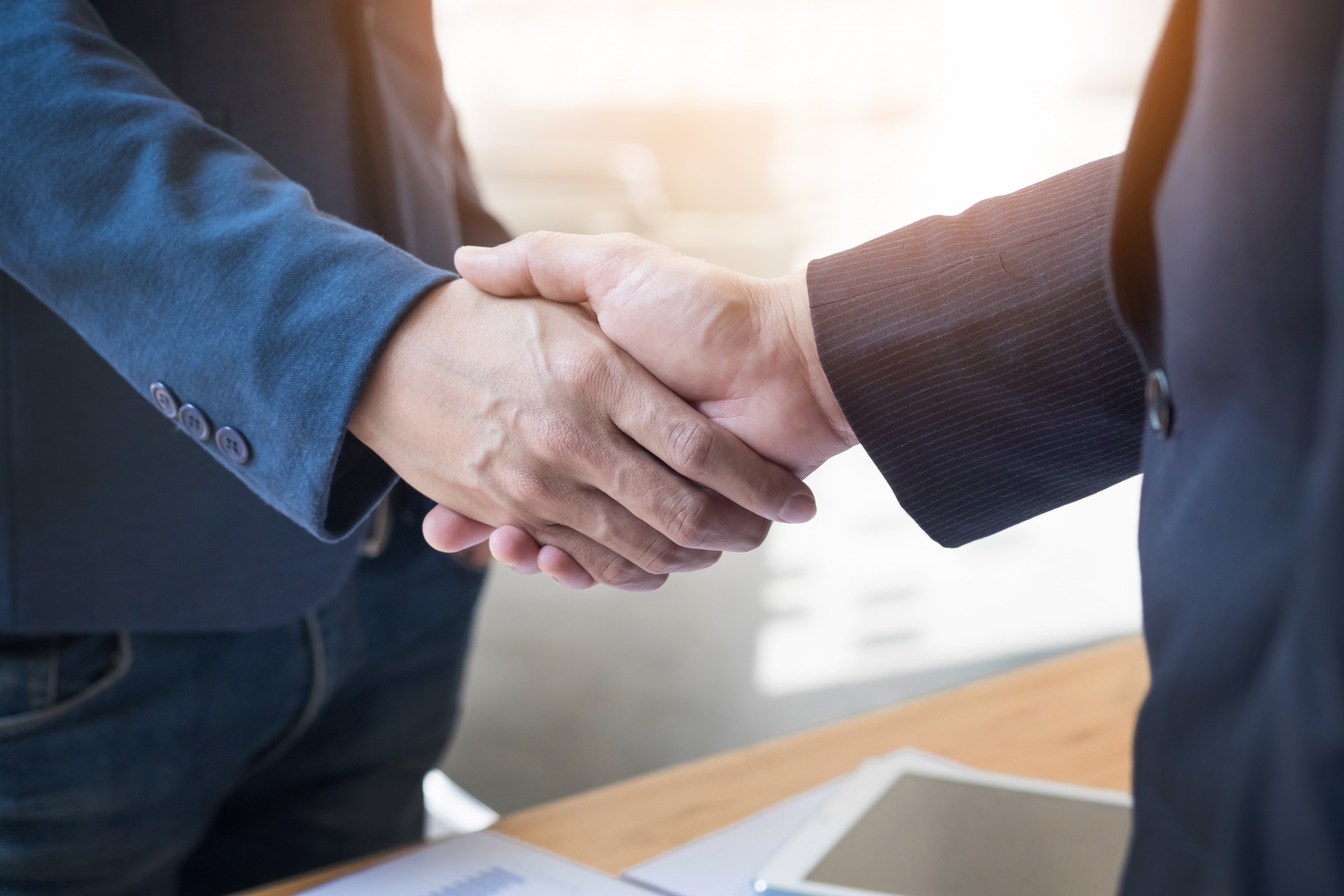 Image of a handshake between two professionals, representing reliable corporate car rental services from Micro Car Rental in Islamabad.